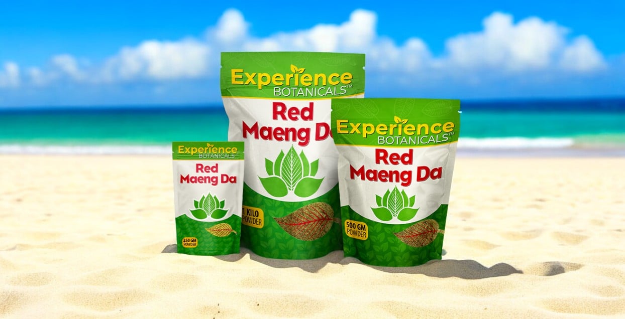 Three packages of Experience Red Maeng Da Powder are displayed on a sandy beach with an ocean and blue sky in the background.